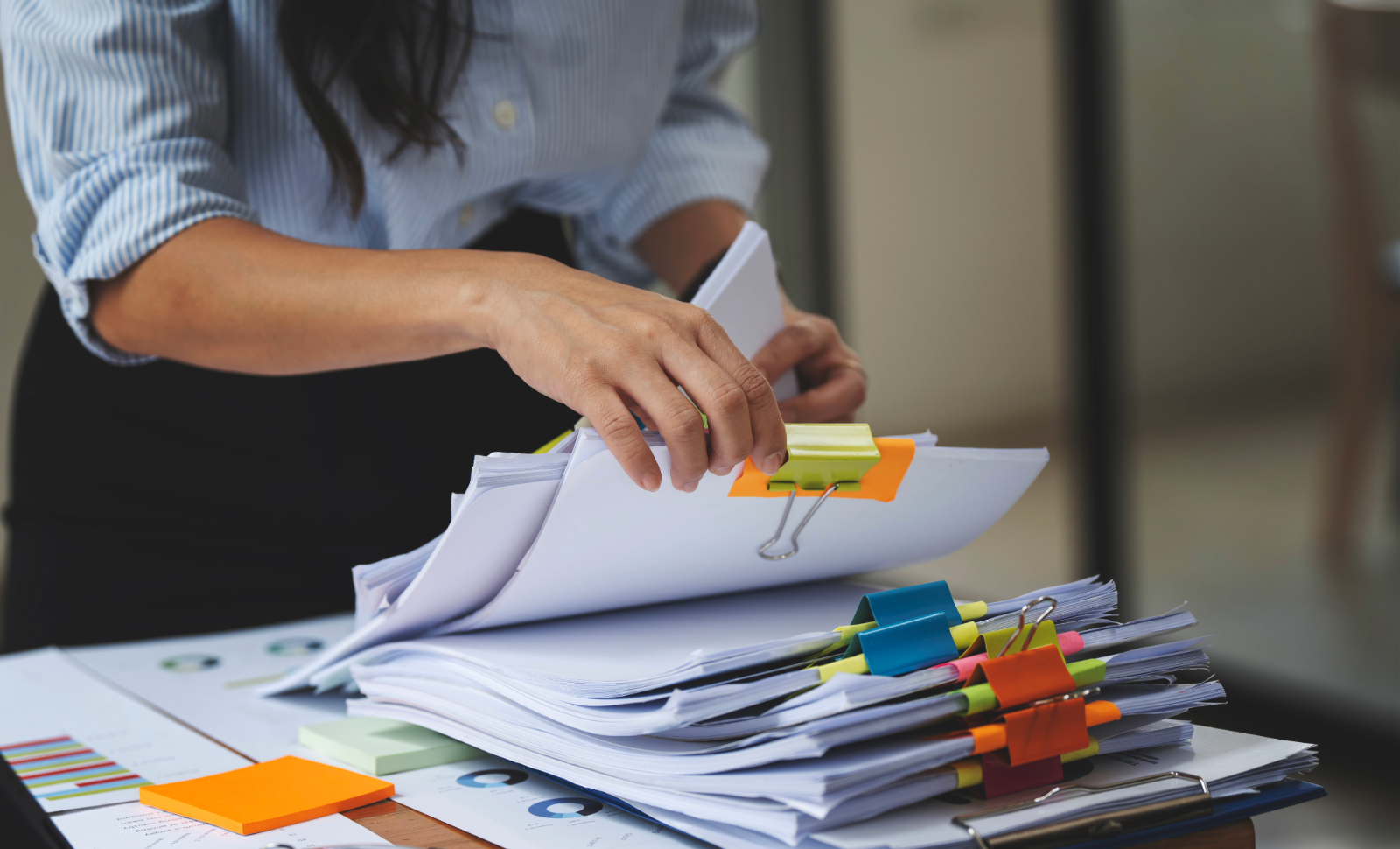 Public adjuster in an office looking through organized documents