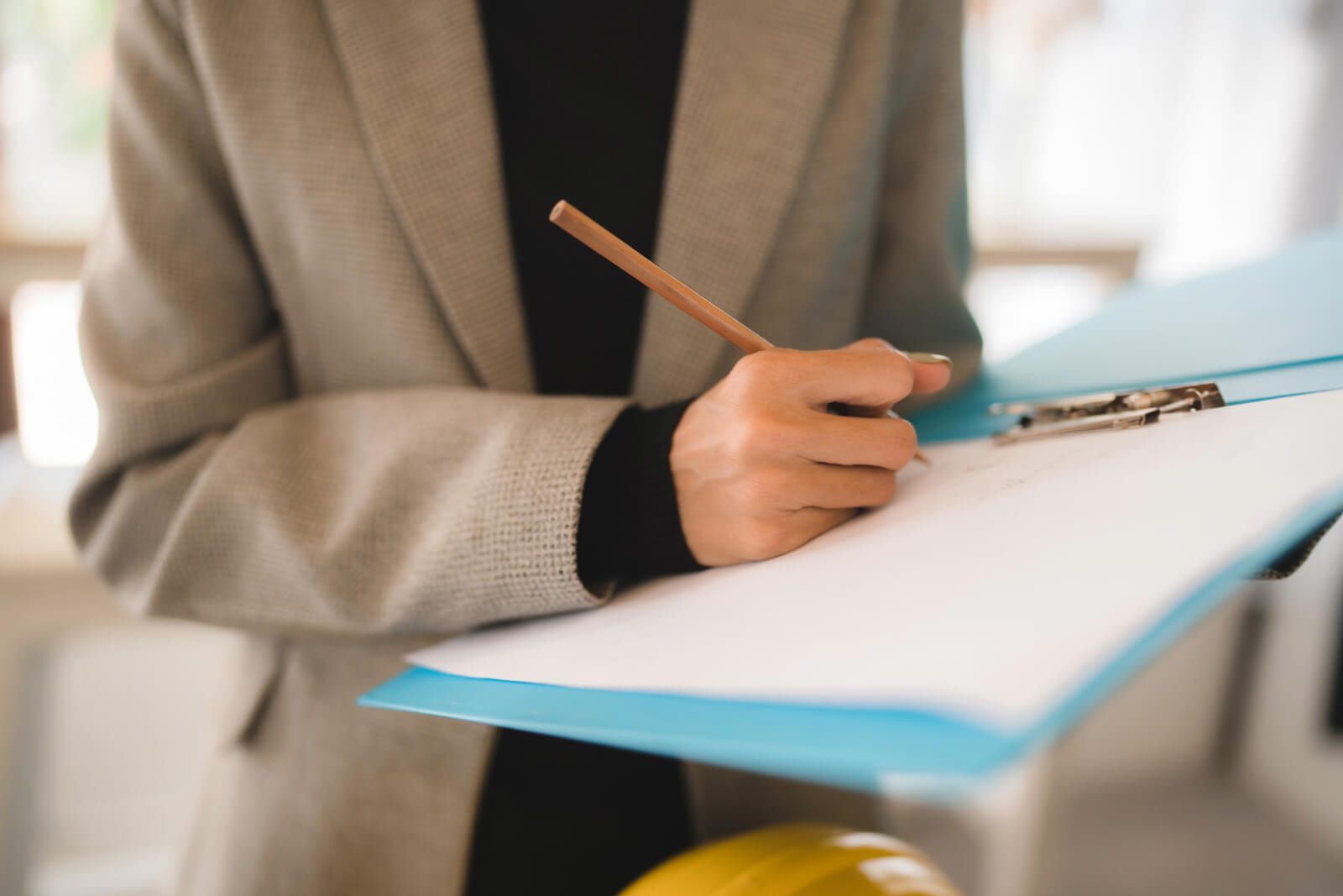 Public adjuster holding a clipboard and pencil while inspecting a property