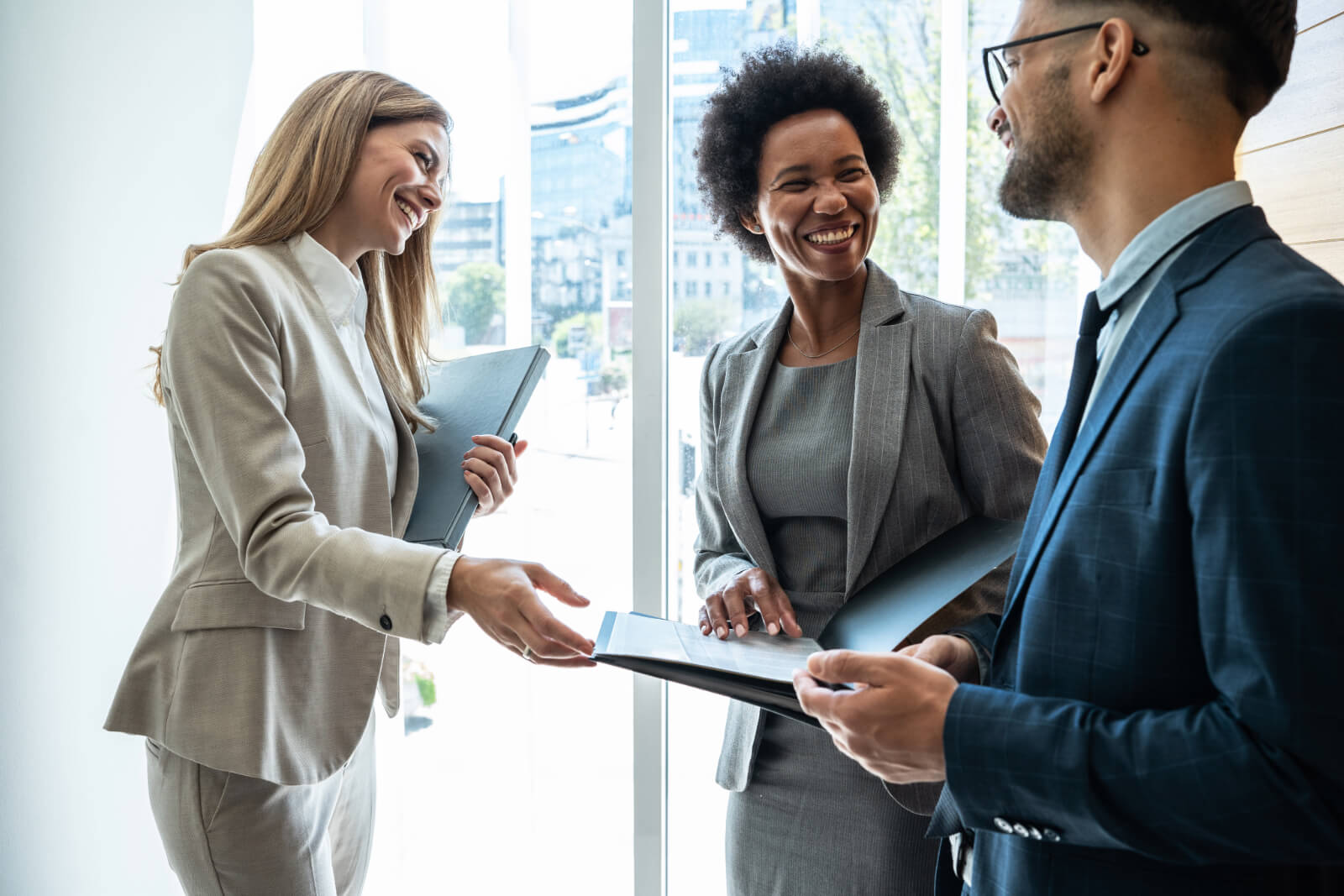 Group of three public adjusters chatting inside of a corporate building