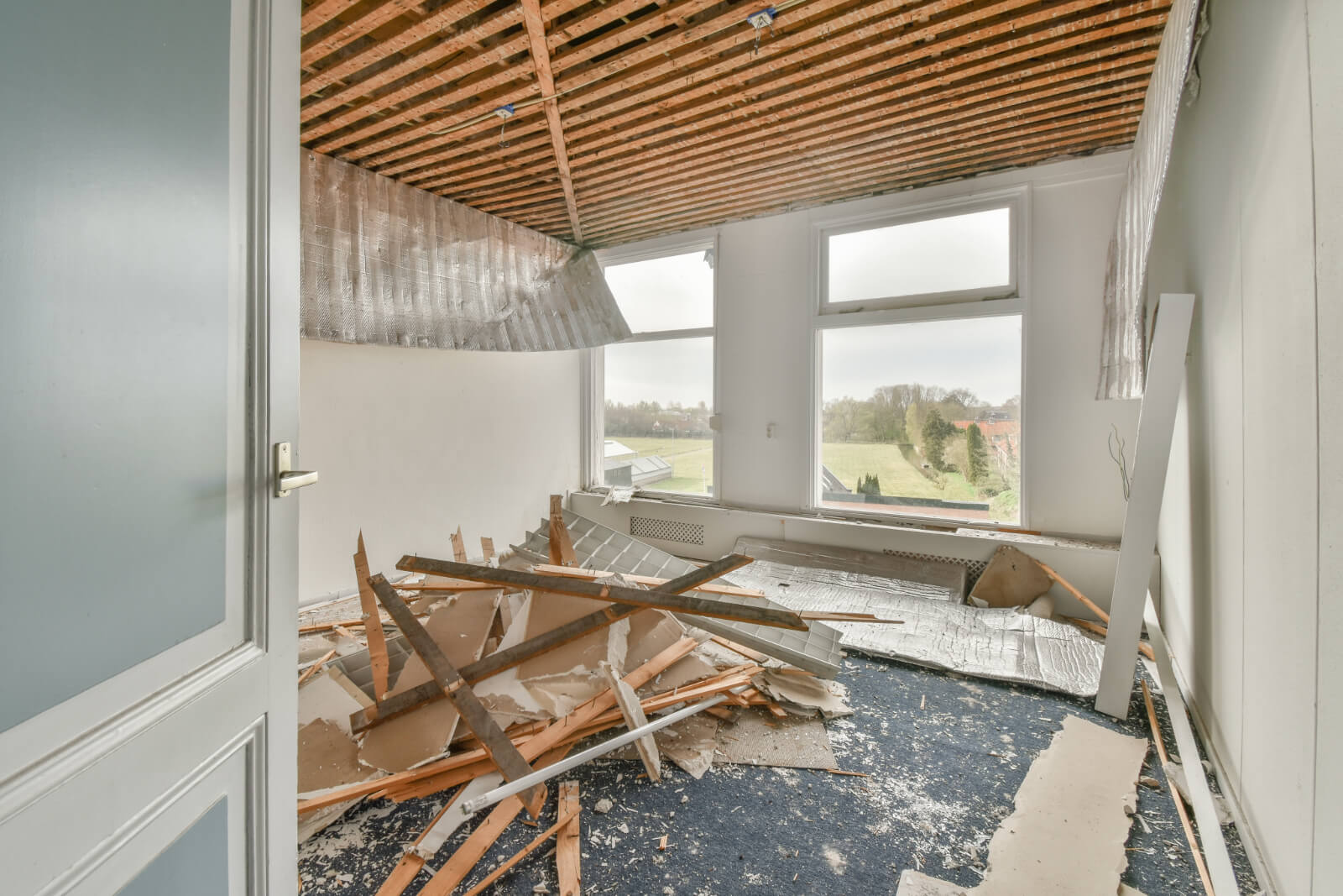 Pile of wood lays inside a room due to a collapsed ceiling
