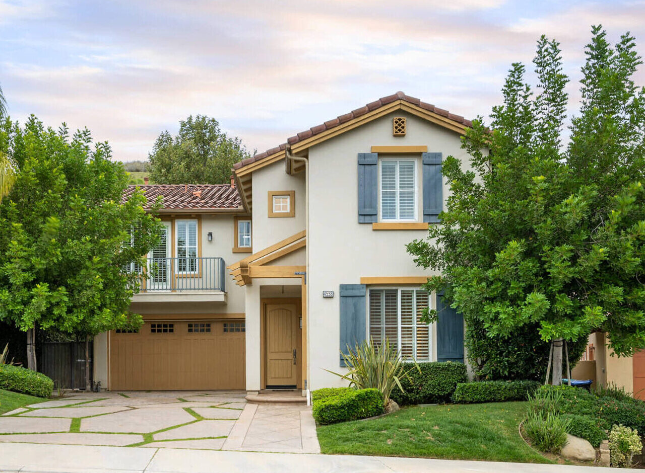 Beautiful two story, Californian home with shrubbery and large trees