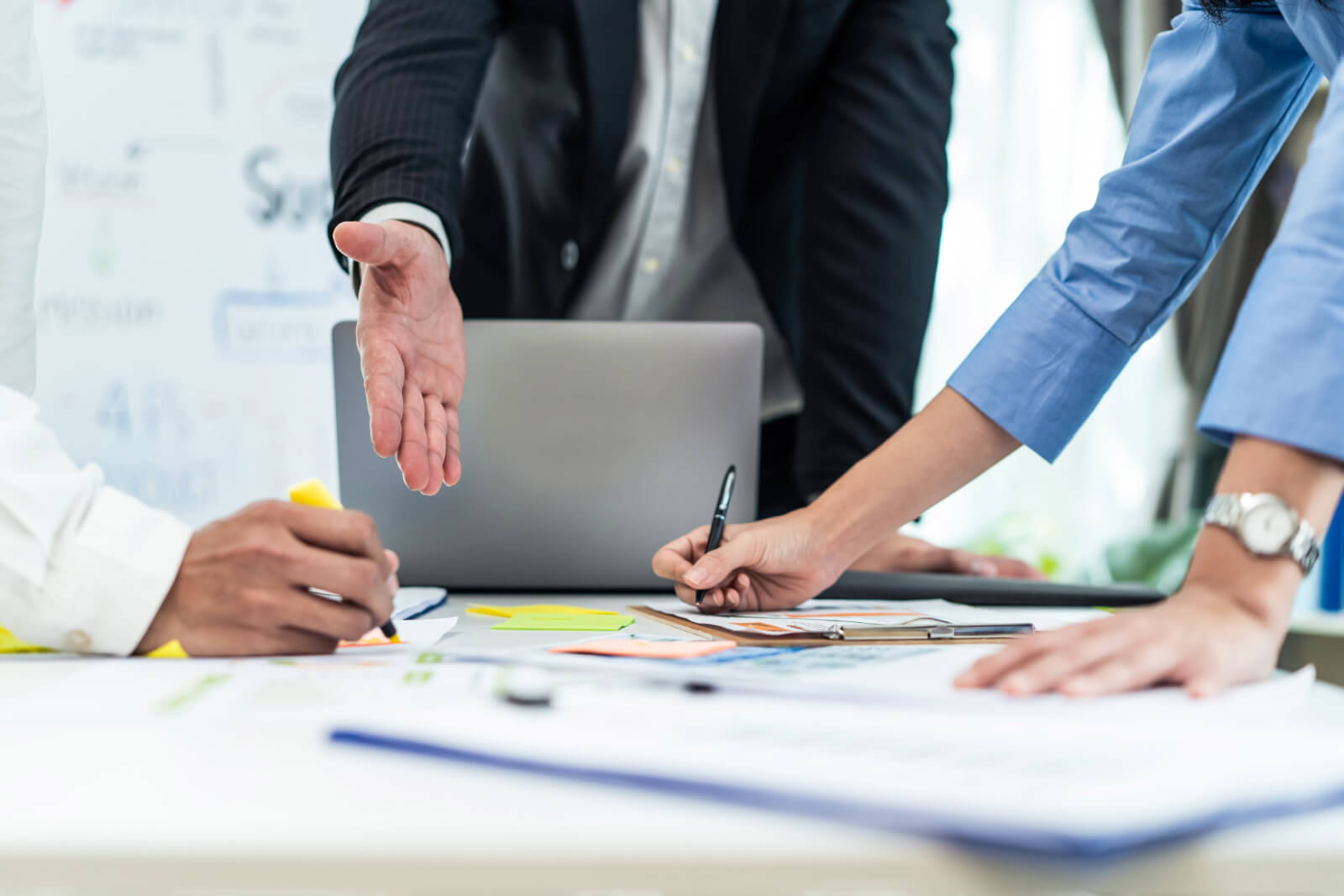 Group of three public adjusters discussing negotiation tactics